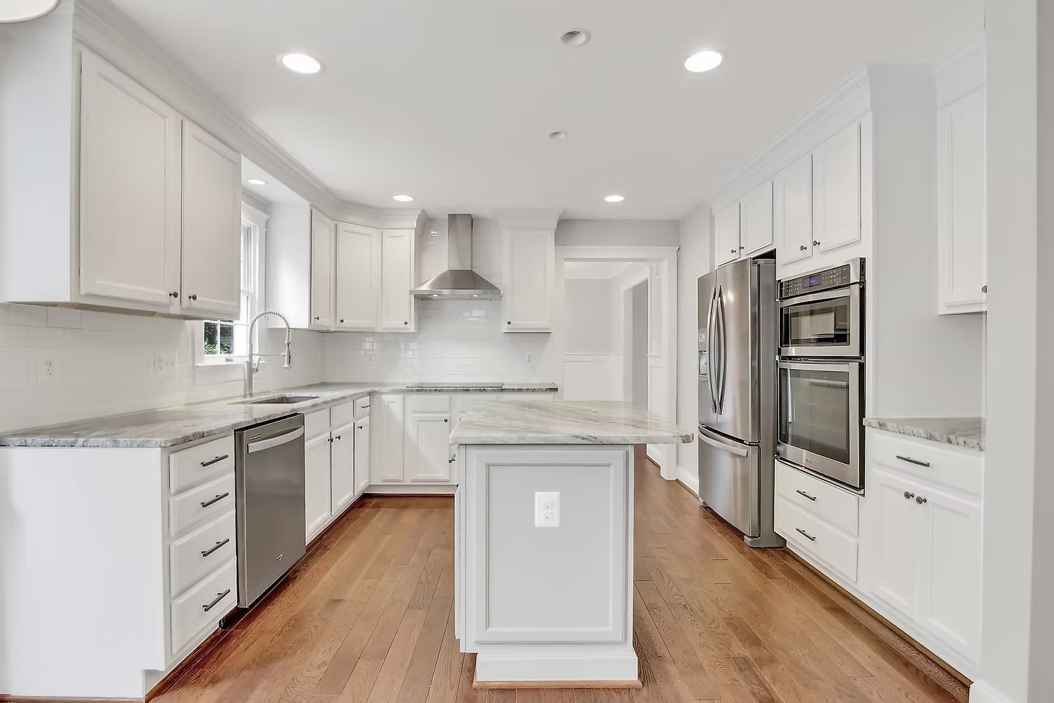 White custom kitchen with island and hardwood floors