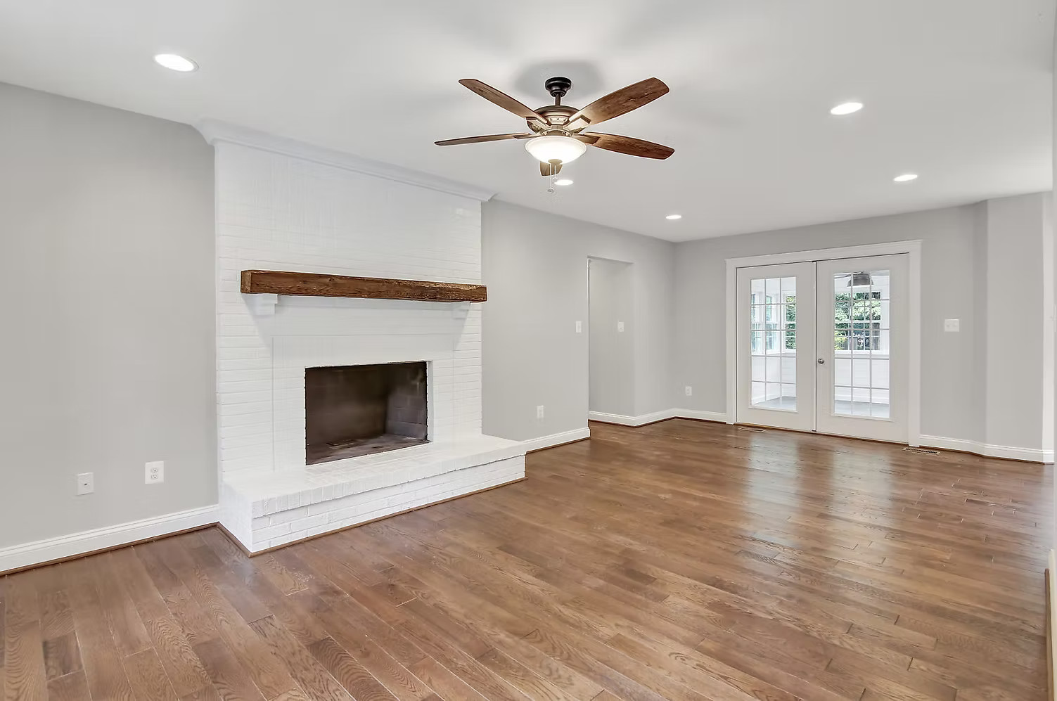 Living room with white fireplace and wood mantel