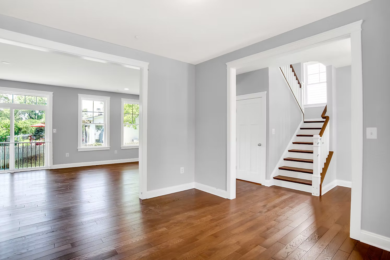 Bright living space with staircase and hardwood floors